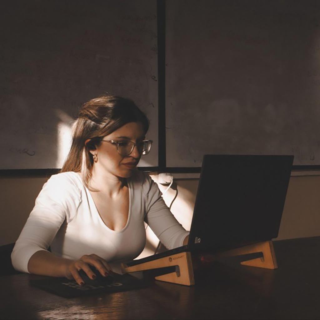 woman working on laptop in dimly lit room