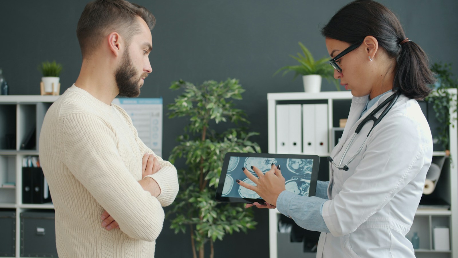 Doctor shows patient medical scan on tablet