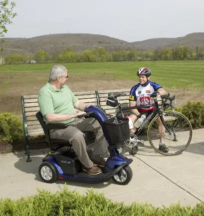 Person riding a blue Pride Victory mobility scooter outdoors