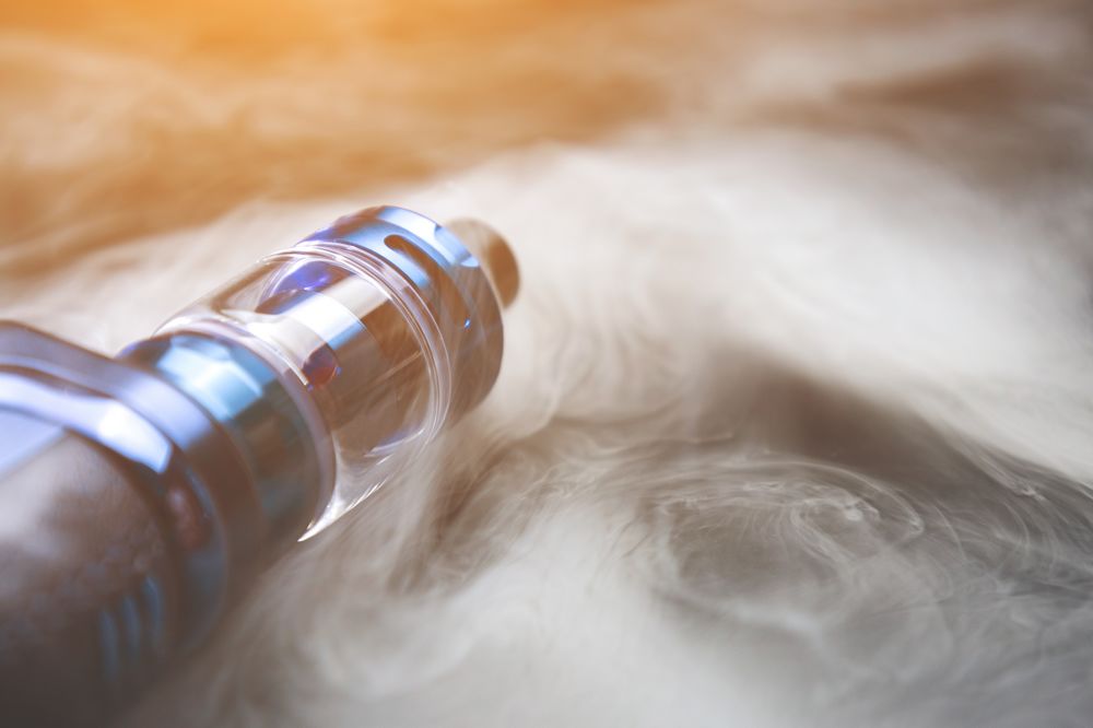 Modern vape device closeup with vapor